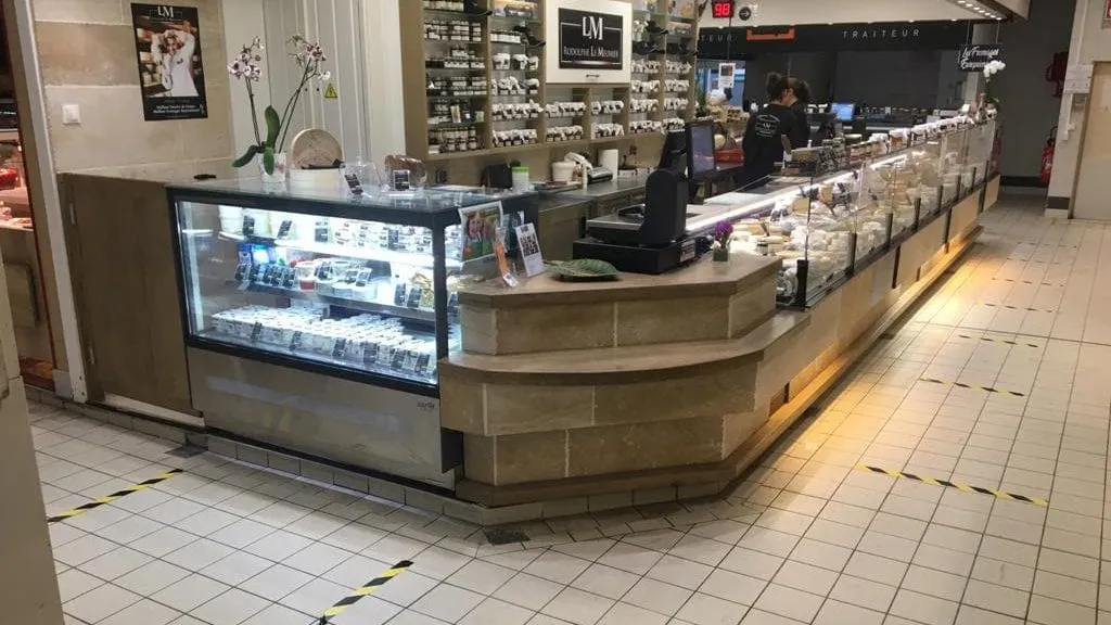 Marquage au sol avec des bandes de rubans adhésifs jaune et noir pour délimiter la distance de sécurité dans un commerce