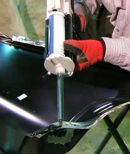Application de la colle époxy structurale Bostik Pliogrip 5761B au pistolet sur un panneau de carrosserie